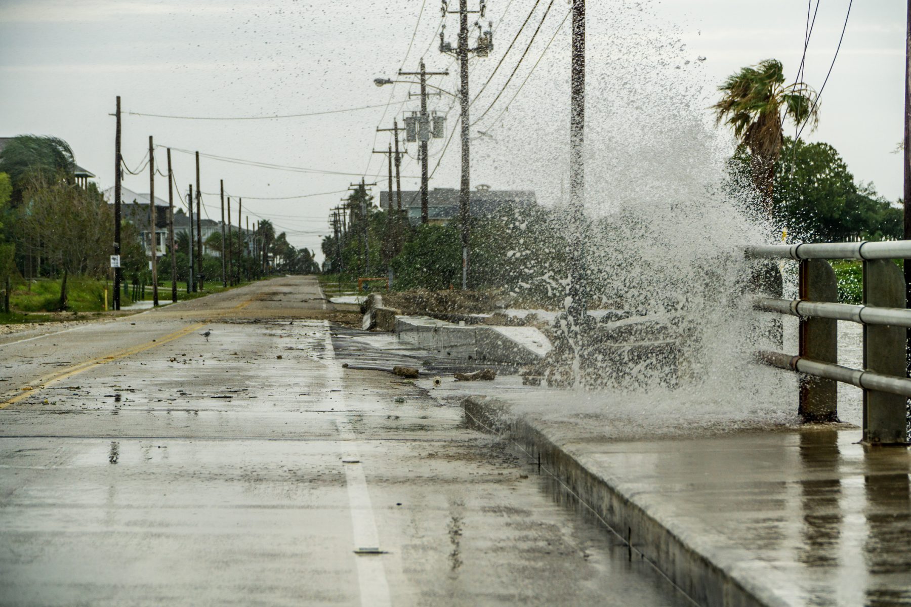 Water crashing onto the road during a hurricane.